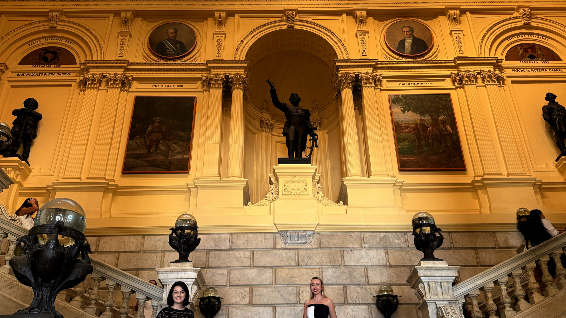 Parte interna amarela do Museu do Ipiranga decorado com quadros e estátuas.